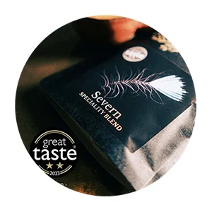 bag of coffee on copper table with great taste award logo