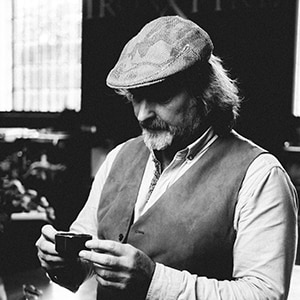 Image of Kev in black and white, looking at a cup of coffee