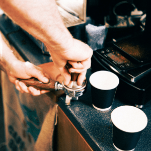 A tamp being used to tamp the coffee in the portafilter.