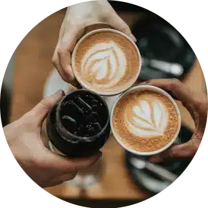 Circular image of three people holding coffee to represent the social and mental benefits of drinking coffee.